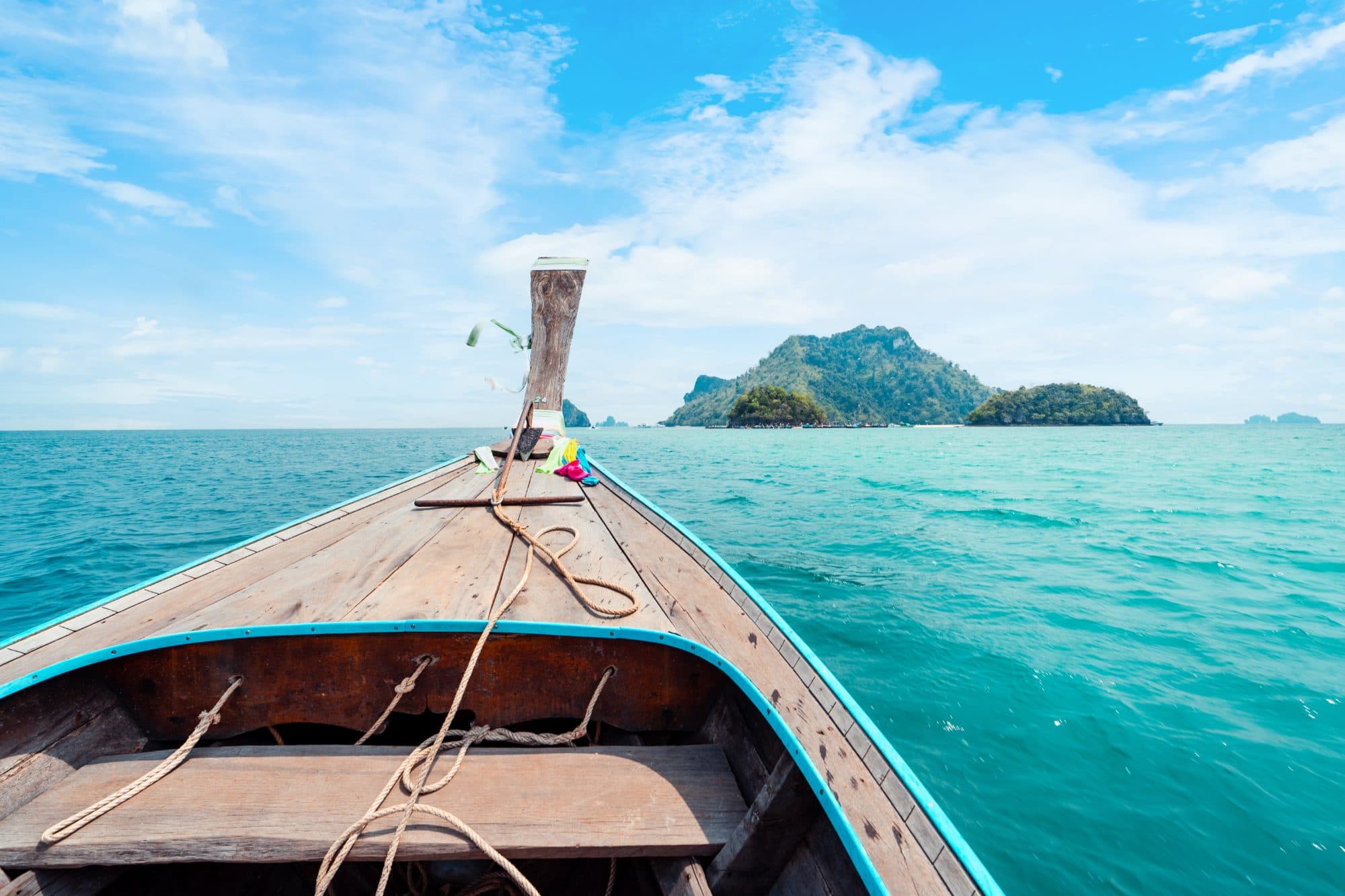 Longtail boat moored in a turquoise karst bay