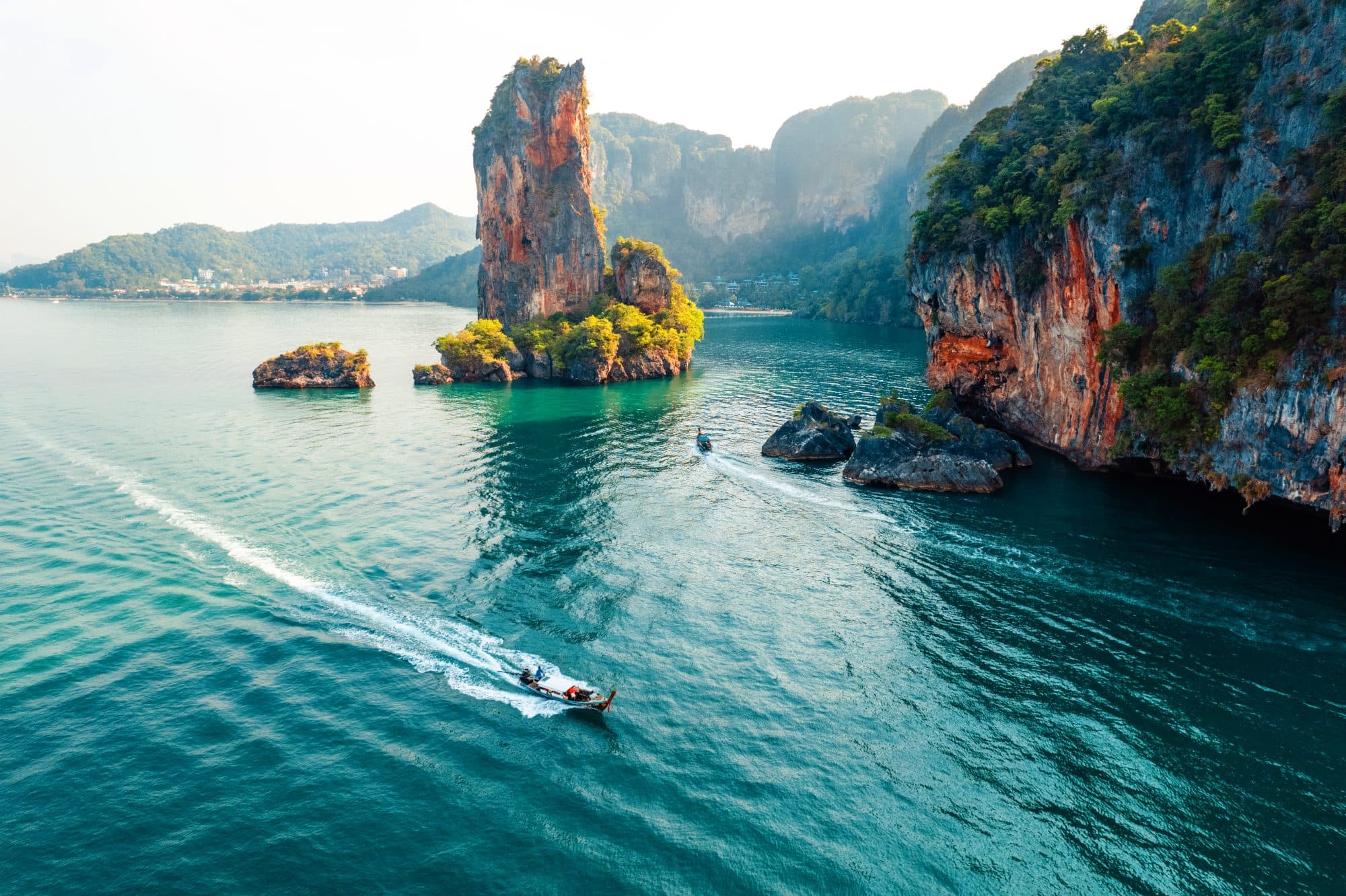 Golden-hour boats among limestone karsts in Thailand